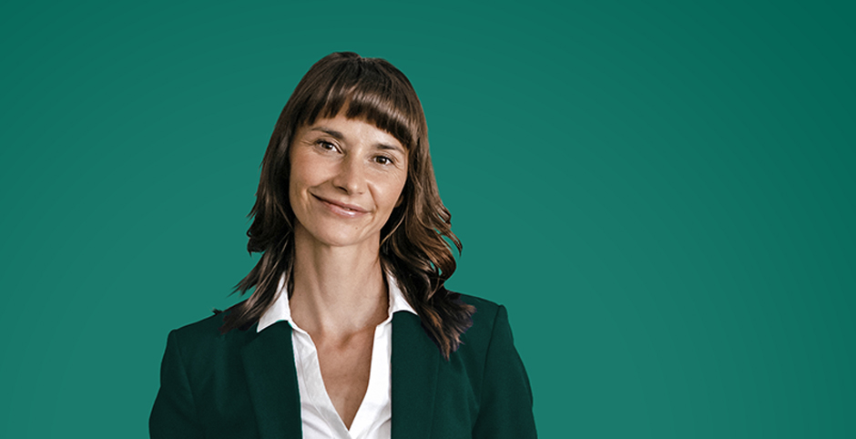 Portrait of a smiling businesswoman against a green background.